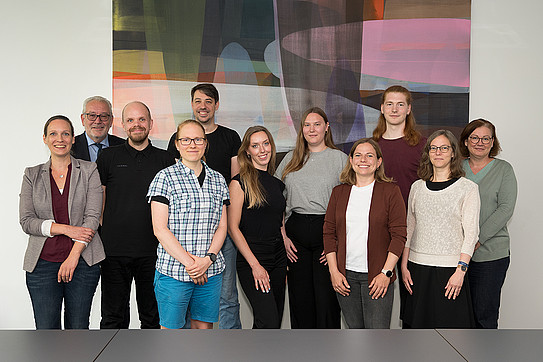 Group of young people in front of a modern tapestry