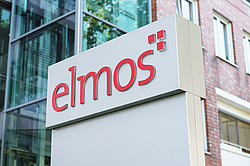 A photo of a sign with the inscription “elmos” in front of a company building