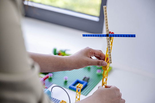 A person's hands hold a structure created in a student laboratory.