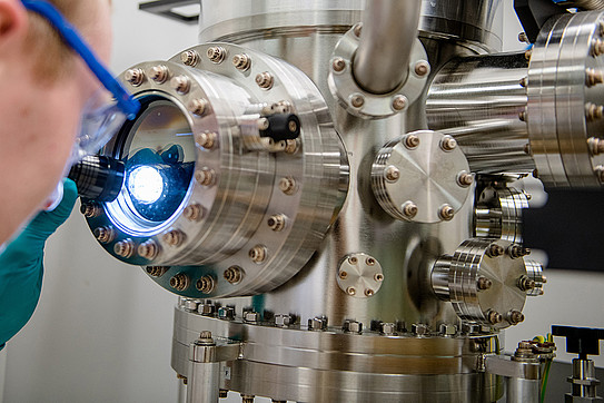 Cutaway from a person shining a flashlight into the opening of an apparatus