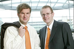 Two men in suits with orange ties