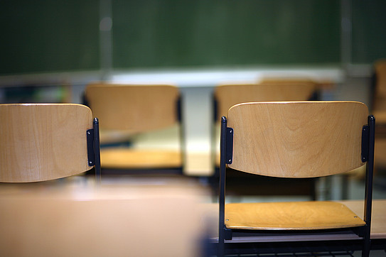 Chairs placed on tables in a classroom