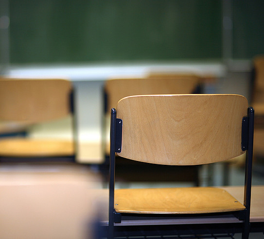 Auf Tische gestellte Stühle in einem Klassenzimmer