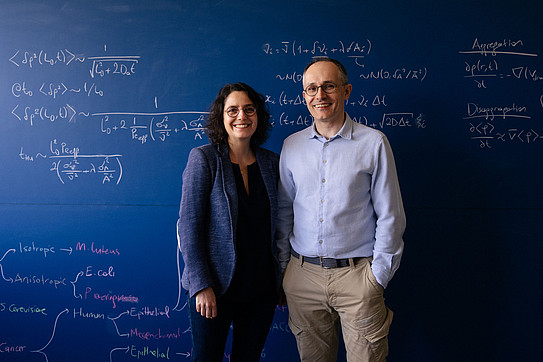 Foto von Serim und Ömer Ilday vor einer Tafel mit mathematischen Gleichungen.