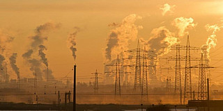 Smoking chimneys against an orange sky.