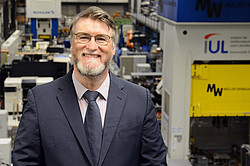 Portrait of Prof. Yannis P. Korkolis, with a machine hall in the background