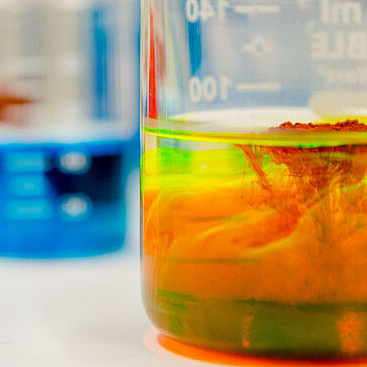 A photo of three test tubes containing colorful liquids.