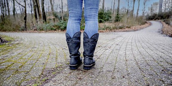 A person is standing at a fork in the road.