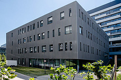 Photo: A modern, gray building in the sunshine.