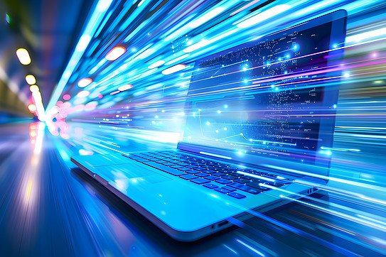 Photo: An open laptop is standing on a surface. Animated blue rays of light fly across the screen.