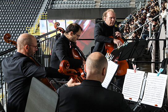 Cello quartet playing for new students at TU Dortmund University in a stairwell at Signal Iduna Park