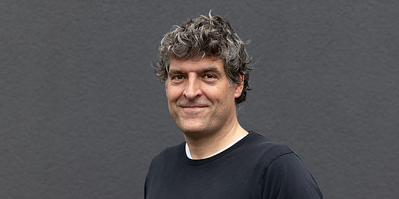Portrait of Gregor Leander against a gray wall