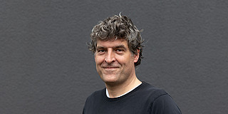 Portrait of Gregor Leander against a gray wall