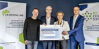 Photo: Science Minister Ina Brandes presents the funding decision to Dr. Peter Salden, Martin Bovermann, and Professor Malte Persike, team leads of the KI:Expertisezentrum.nrw.