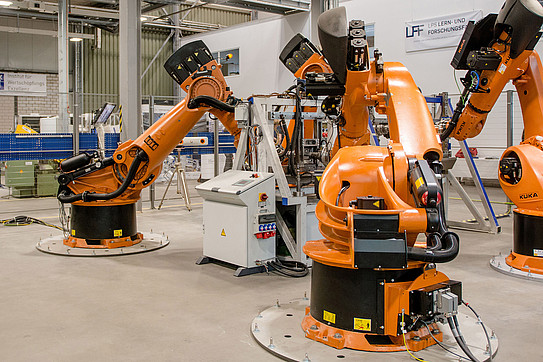 Industrial hall where orange industrial robots perform tasks